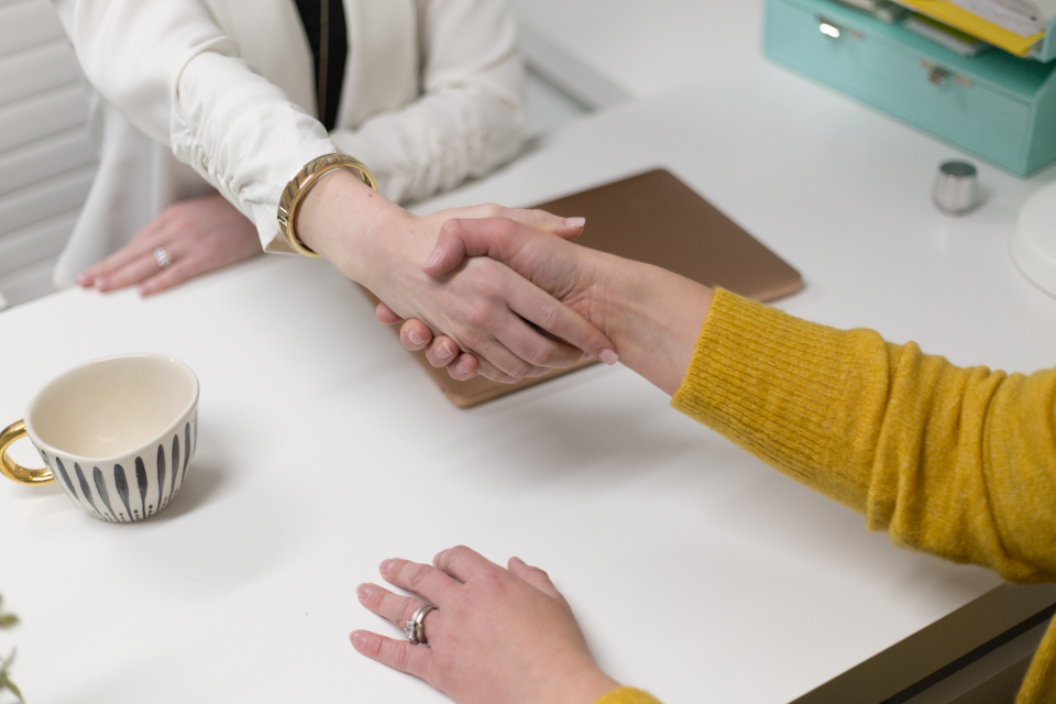 Two business leaders shaking hands on an acquisition agreement