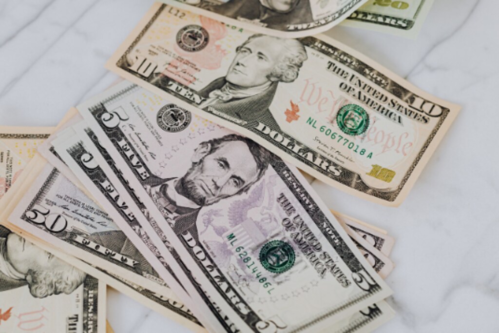US banknotes spread across a marble surface